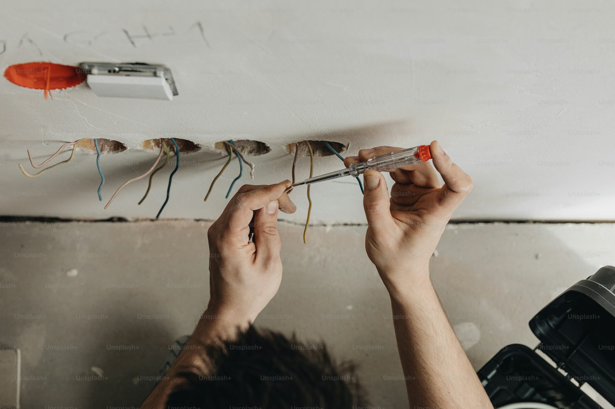 Electrician installing wiring on site